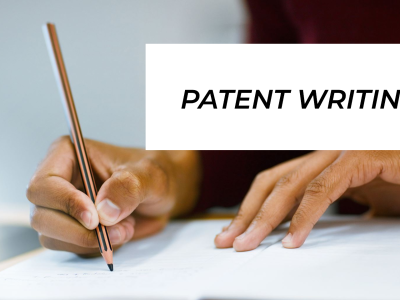 a person writing a patent holding a pencil
